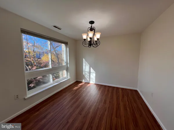 a view of wooden floor chandelier and window in a room