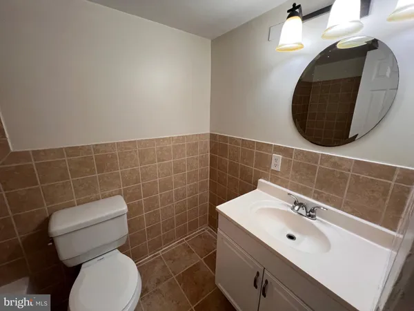 a bathroom with a toilet a sink and mirror