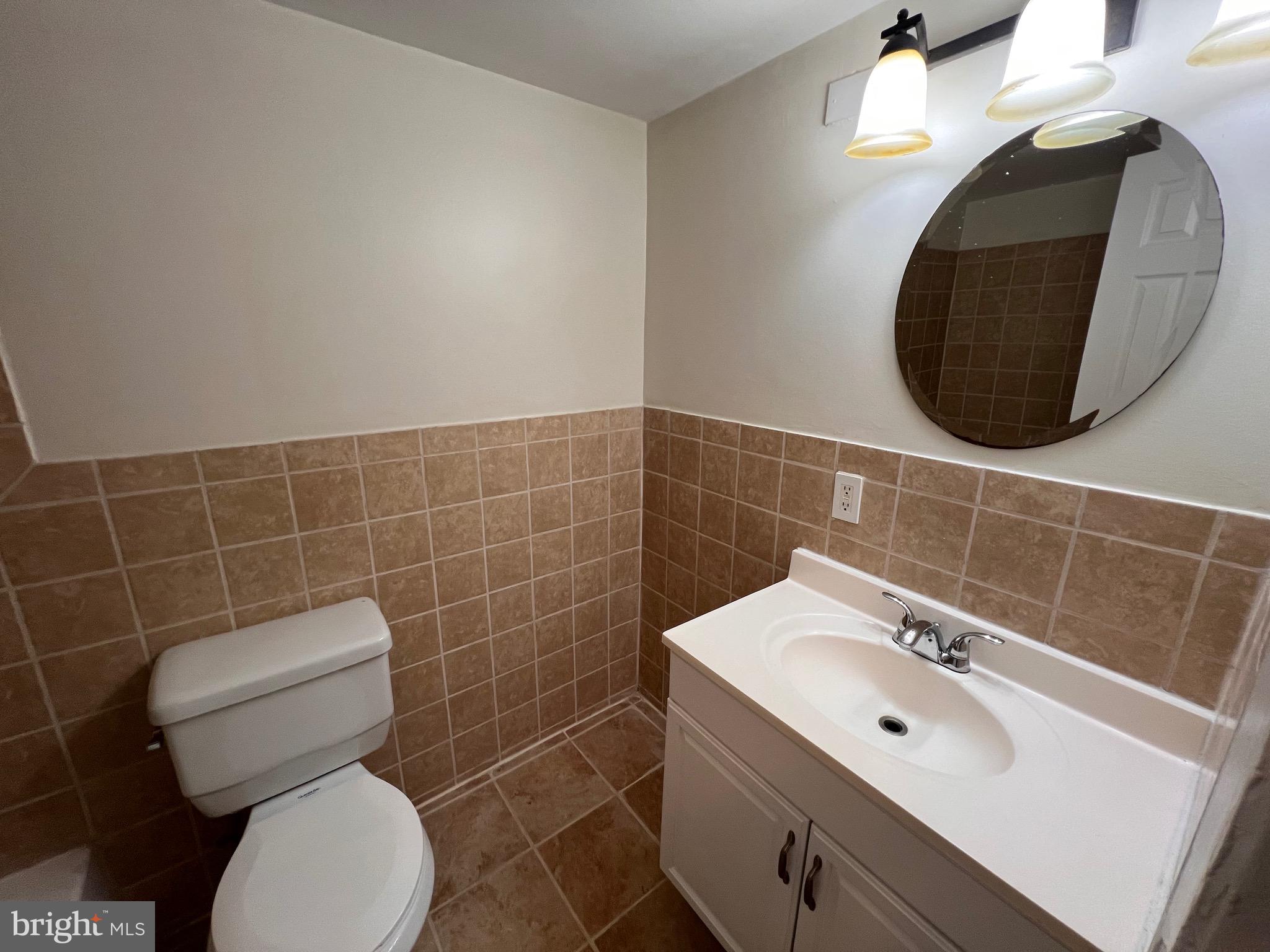 3964 Bel Pre Road, Unit 8 Silver Spring, MD 20906 - Photo 5 of 16 a bathroom with a toilet a sink and mirror