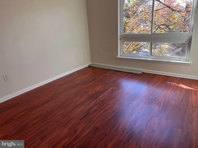 a view of a room with wooden floor and a window