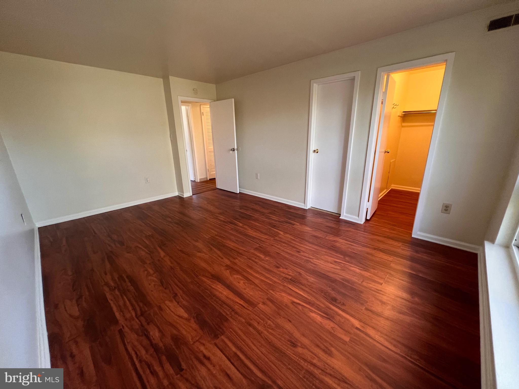 3964 Bel Pre Road, Unit 8 Silver Spring, MD 20906 - Photo 9 of 16 a view of an empty room with wooden floor and a window