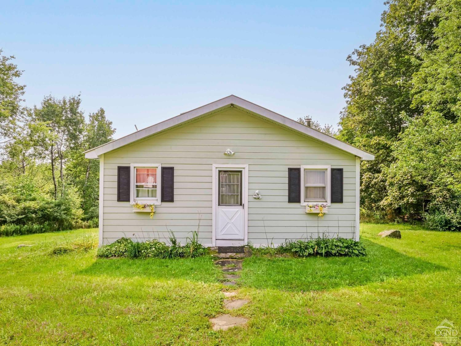 a front view of house with backyard and green space