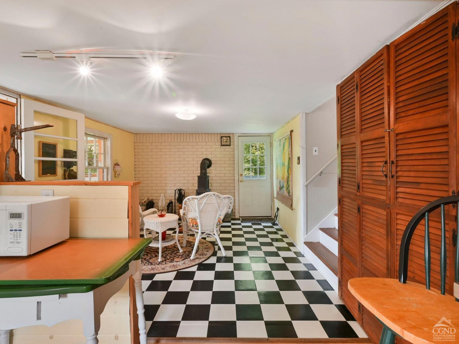 157 Horseshoe Road Conesville, NY 12076 - Photo 14 of 48 a living room with a black white checkered floor with a dining table and chairs
