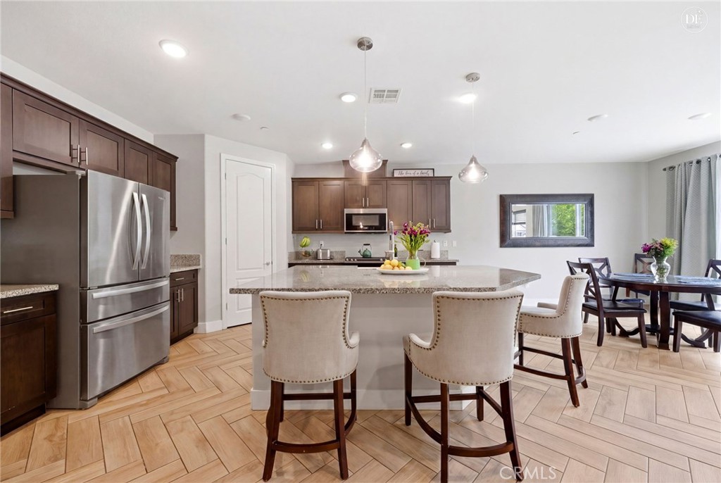 20948 Center Street Riverside, CA 92507 - Photo 26 of 92 a kitchen with a dining table chairs refrigerator and microwave