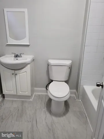 a bathroom with a sink toilet and a mirror