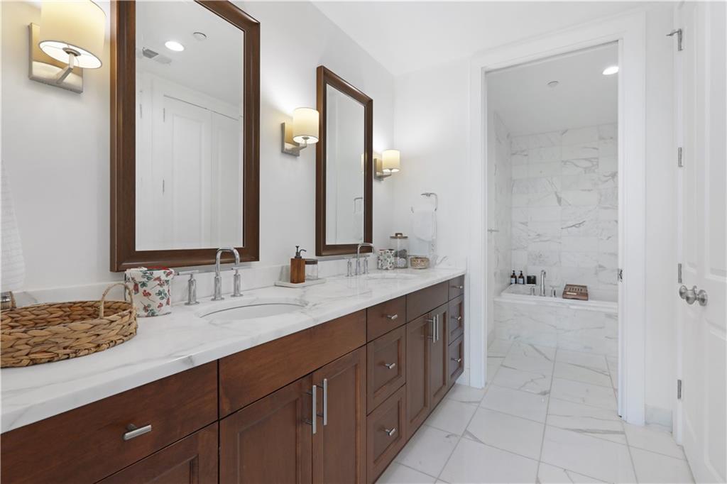 3630 Peachtree Road Northeast, Unit 2005 Atlanta, GA 30326 - Photo 12 of 32 a bathroom with a double vanity sink a mirror and a bathtub