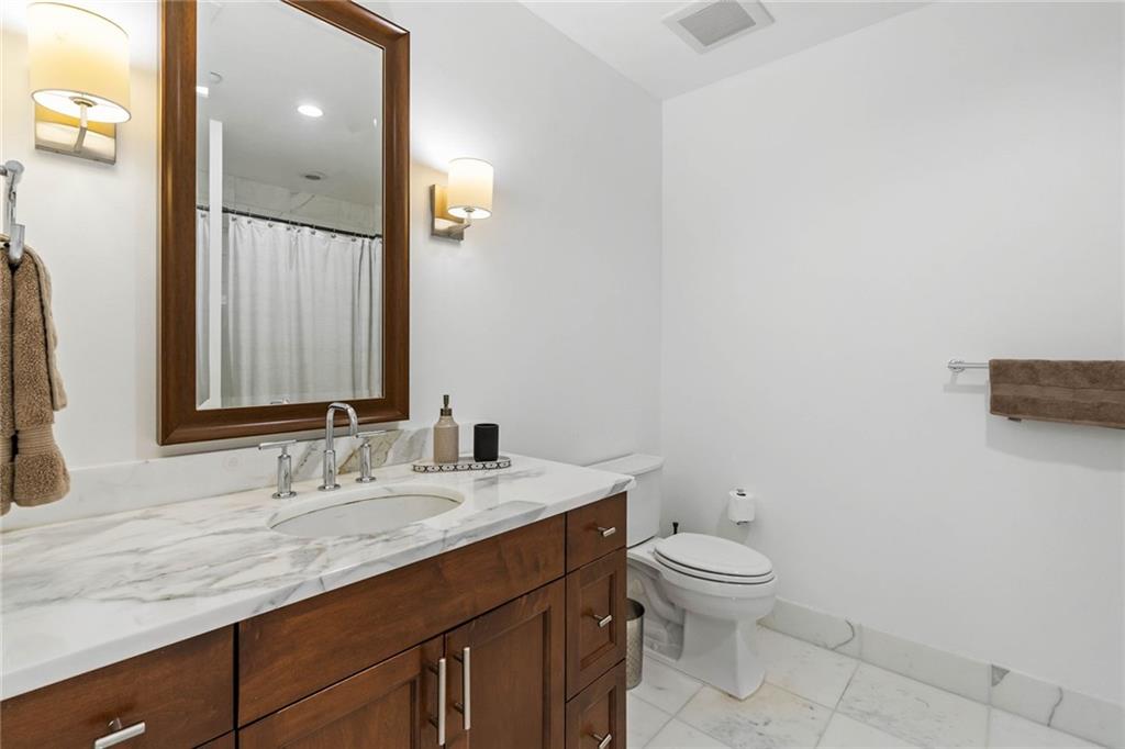 3630 Peachtree Road Northeast, Unit 2005 Atlanta, GA 30326 - Photo 15 of 32 a bathroom with a granite countertop sink a toilet and a mirror