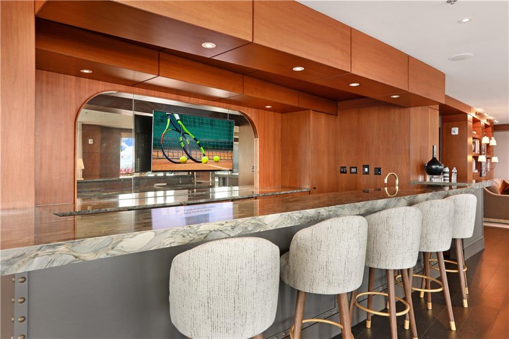 3630 Peachtree Road Northeast, Unit 2005 Atlanta, GA 30326 - Photo 21 of 32 a kitchen with granite countertop a table chairs stove and granite counter top