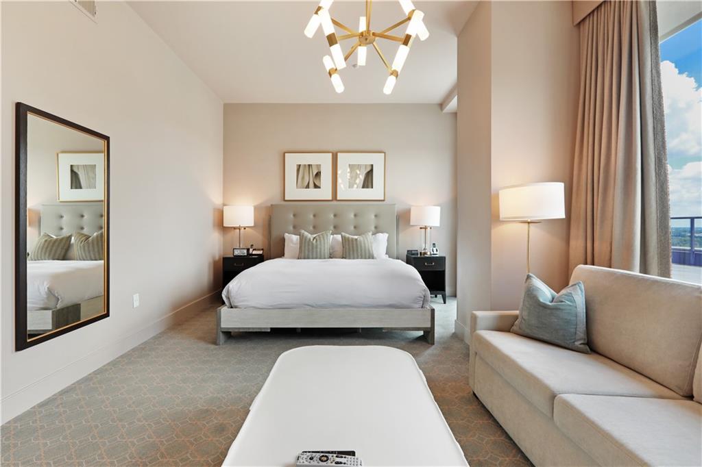 3630 Peachtree Road Northeast, Unit 2005 Atlanta, GA 30326 - Photo 30 of 32 a bedroom with a large bed and a chandelier