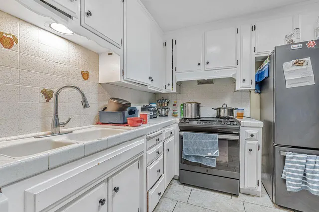 a kitchen with cabinets appliances and a refrigerator
