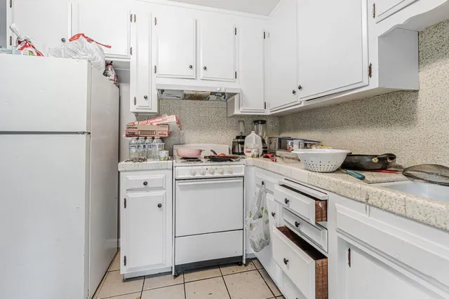 a kitchen with a refrigerator sink and cabinets