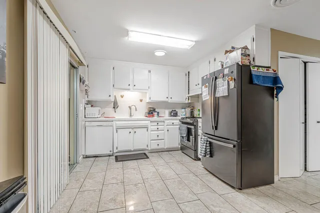 a kitchen with white cabinets and appliances
