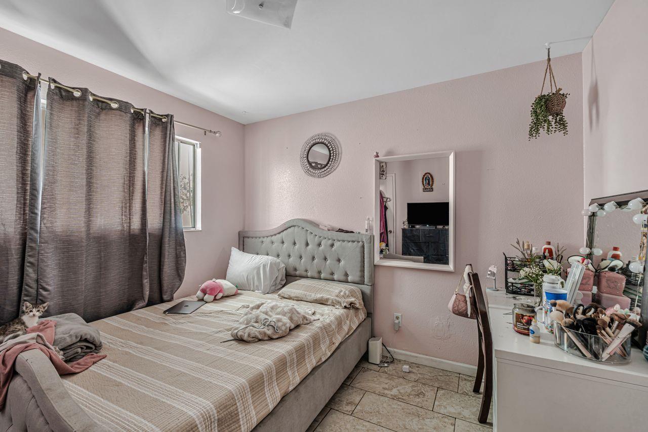 2210 San Blas Court Modesto, CA 95355 - Photo 19 of 28 a bedroom with a large bed and a chandelier