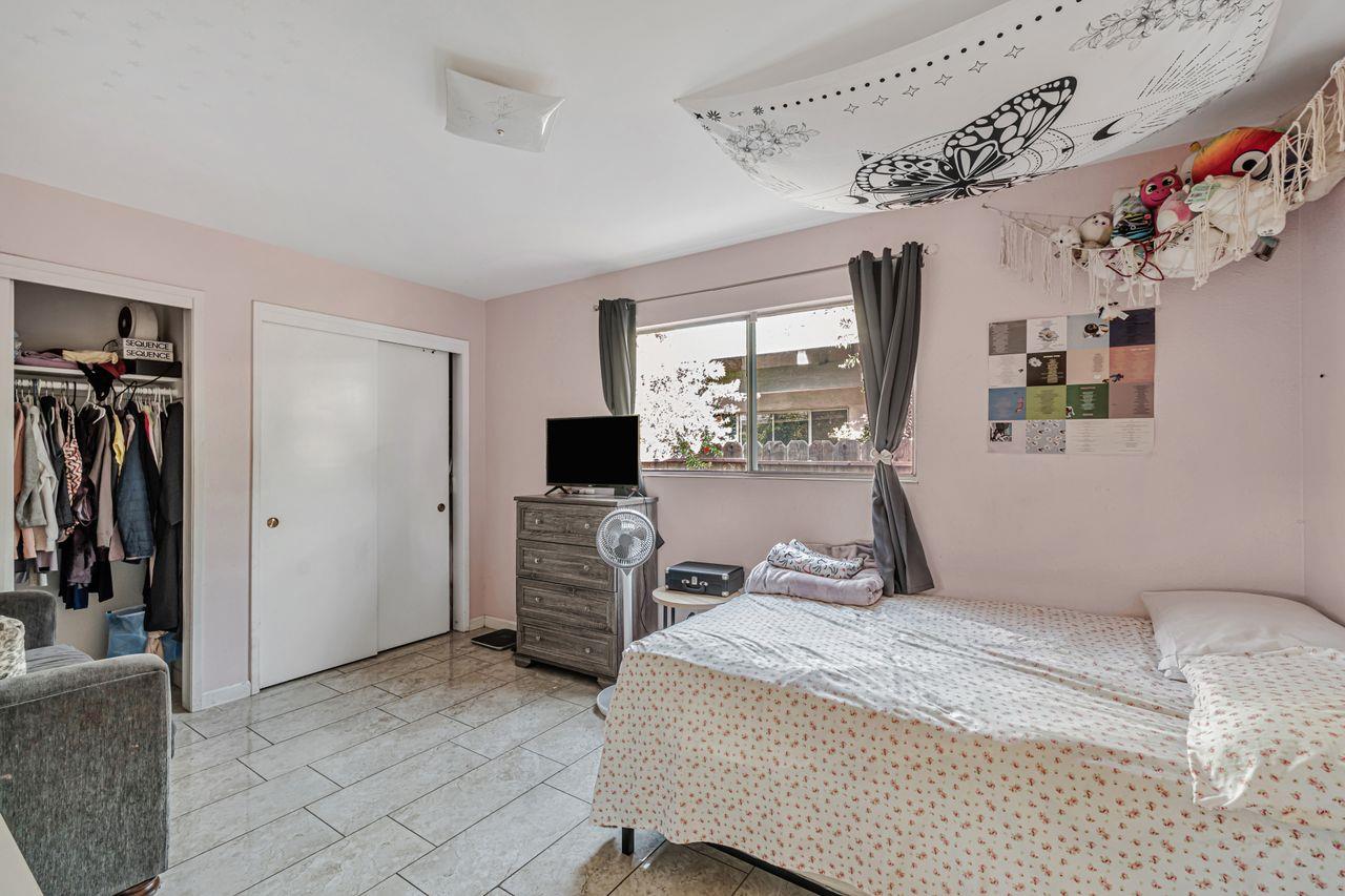 2210 San Blas Court Modesto, CA 95355 - Photo 21 of 28 a bedroom with a bed and a flat tv screen on the dresser