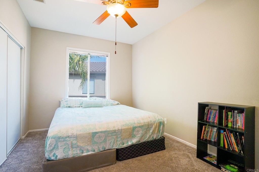 629 Sumner Way, Unit 2 Oceanside, CA 92058 - Photo 16 of 21 a bedroom with a bed and a chandelier