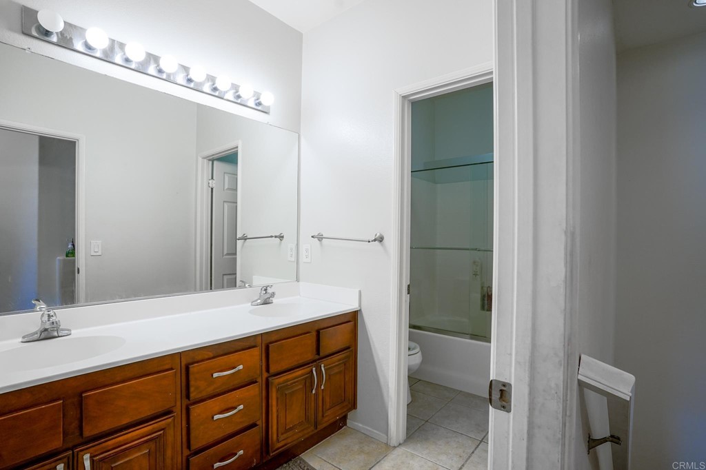 629 Sumner Way, Unit 2 Oceanside, CA 92058 - Photo 21 of 21 a spacious bathroom with a double vanity sink a toilet and a mirror