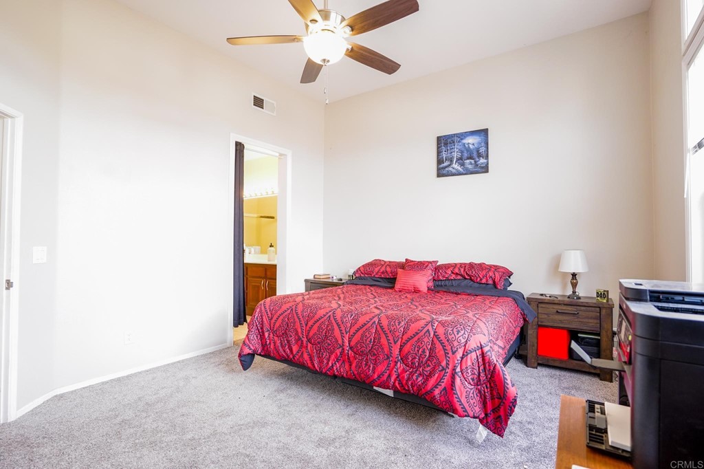 629 Sumner Way, Unit 2 Oceanside, CA 92058 - Photo 10 of 21 a bedroom with a bed and a chandelier fan