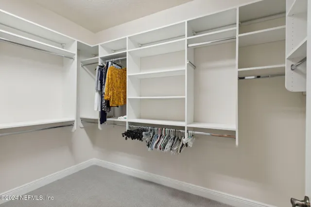 a view of walk in closet with clothes and shoes