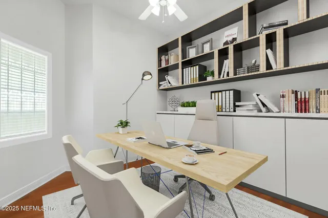 a view of a workspace with furniture and a window