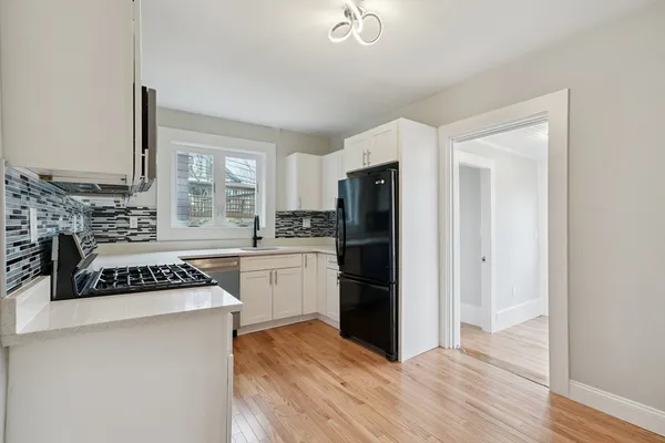 a kitchen with a refrigerator and a stove top oven