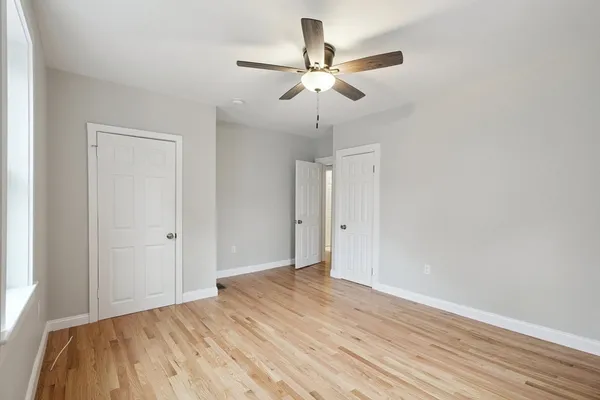 a view of a room with wooden floor and ceiling fan