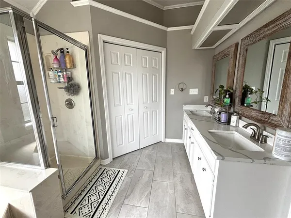 a bathroom with double vanity sink and a mirror