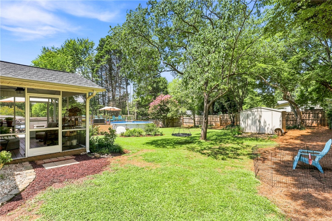 204 Sylvia Road Easley, SC 29642 - Photo 30 of 36 A spacious backyard retreat features an inviting screened porch, lush green lawn, and a sparkling pool for endless enjoyment.