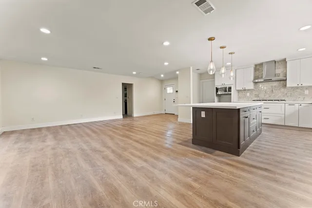 a large kitchen with kitchen island a sink stainless steel appliances and cabinets