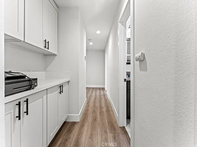 a view of a kitchen with wooden floor and electronic appliances