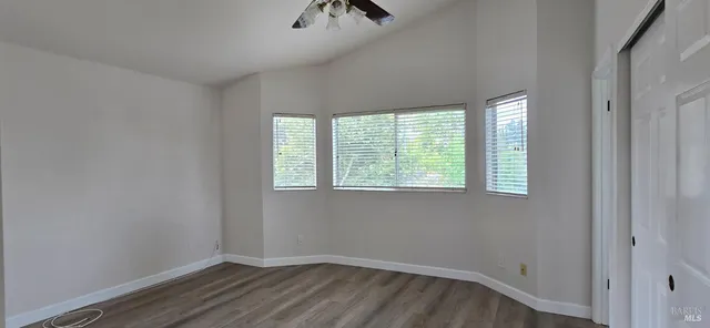 a view of a room that has wooden floor and window
