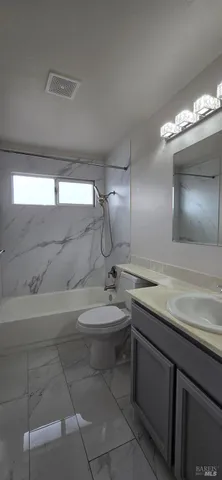 a bathroom with a granite countertop sink a toilet and a mirror