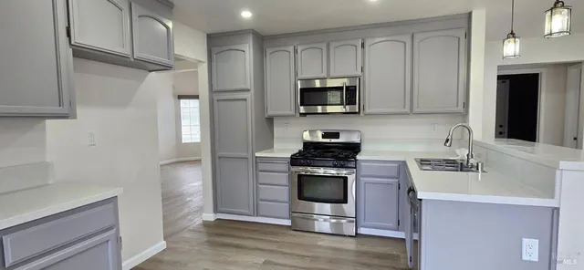 a kitchen with white cabinets stainless steel appliances and a counter space