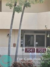 7041 Environ Boulevard, Unit 126 Lauderhill, FL 33319 - Photo 2 of 4 a front view of a house with a yard