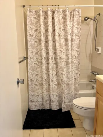 a bathroom with a toilet and a shower curtain