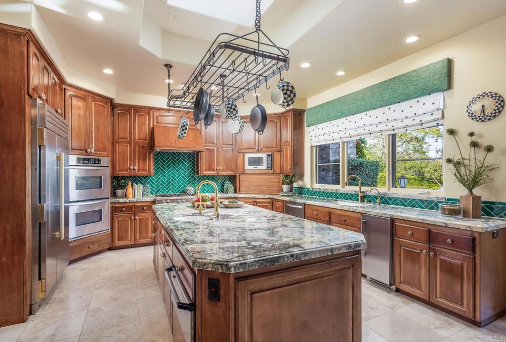 4843 La Jacaranda Rancho Santa Fe, CA 92067 - Photo 13 of 61 a kitchen with stainless steel appliances granite countertop a table and chairs