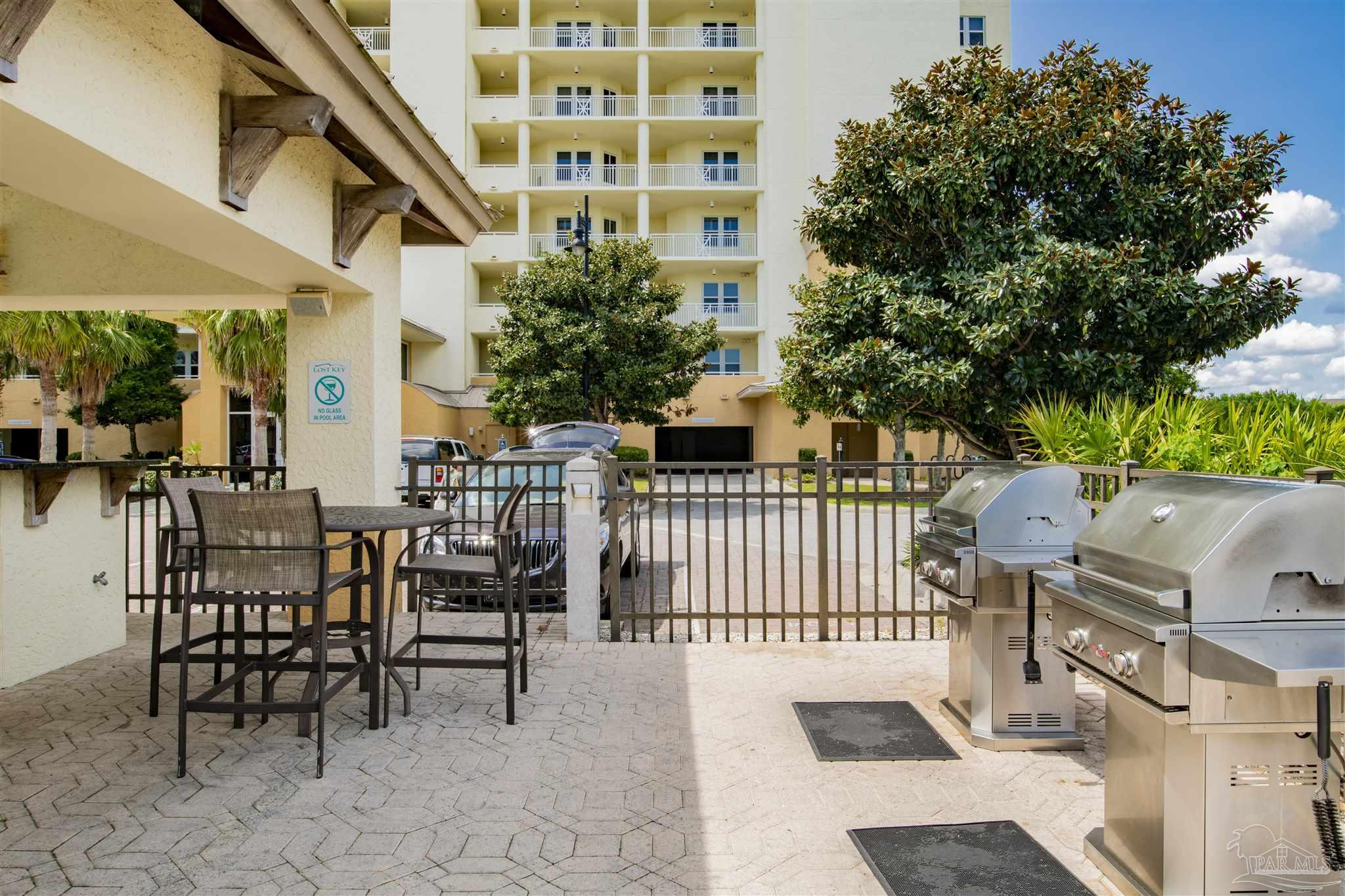 612 Lost Key Drive, Unit 401B Pensacola, FL 32507 - Photo 30 of 34 a view of a patio with couches table and chairs and potted plants