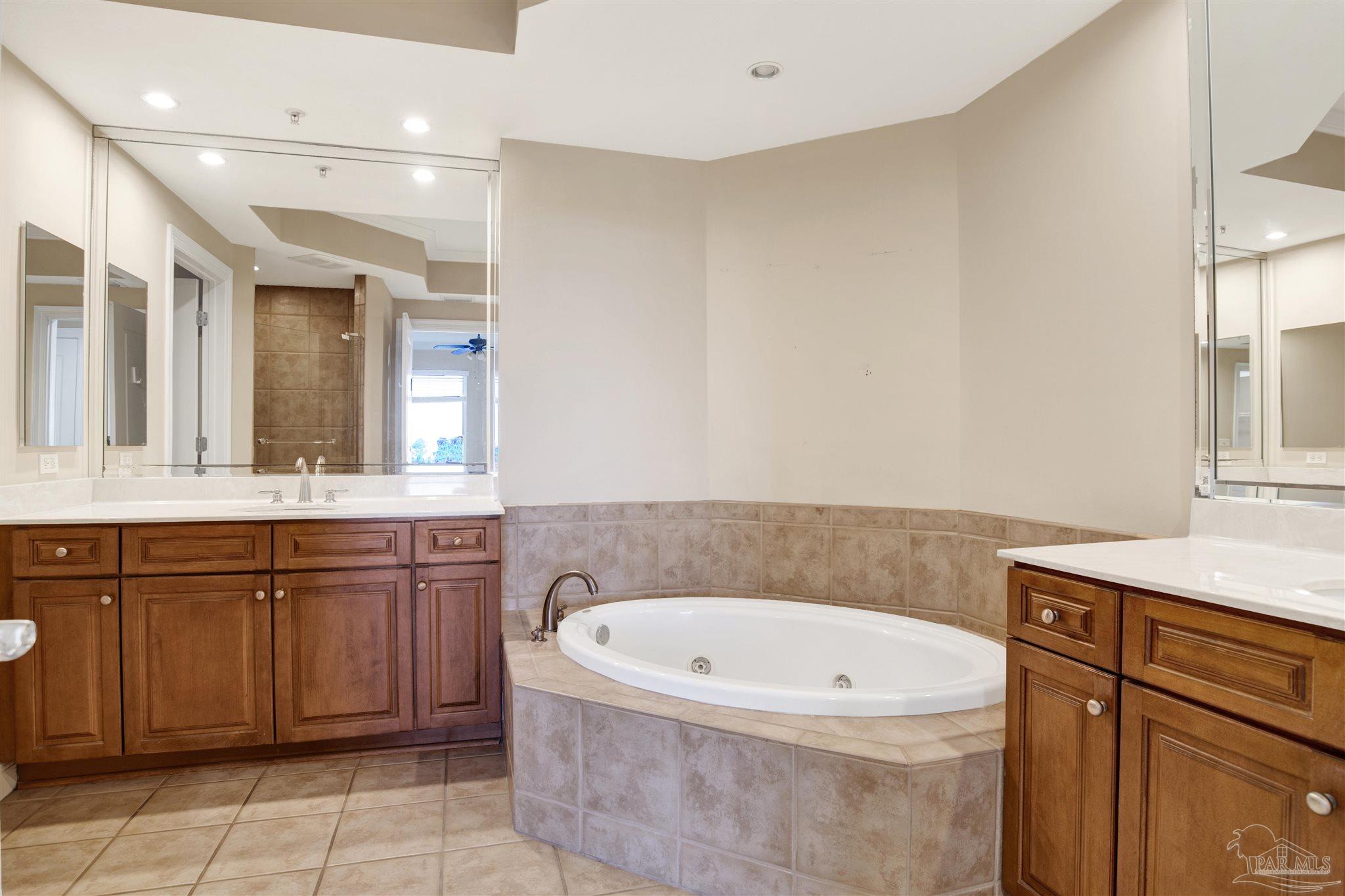 612 Lost Key Drive, Unit 401B Pensacola, FL 32507 - Photo 7 of 34 a bathroom with a granite countertop bathtub sink vanity and mirror