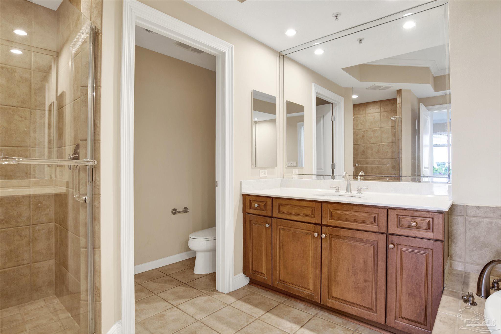 612 Lost Key Drive, Unit 401B Pensacola, FL 32507 - Photo 8 of 34 a bathroom with a granite countertop sink a toilet and a shower