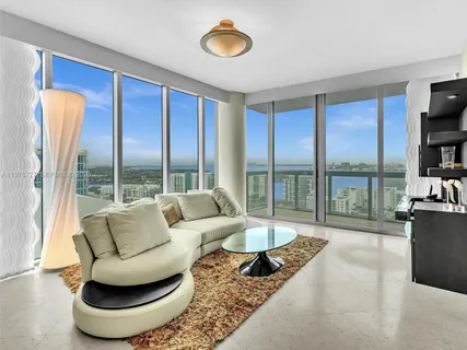 a living room with furniture and a floor to ceiling window