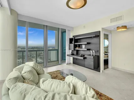 a large bedroom with a bed and glass window