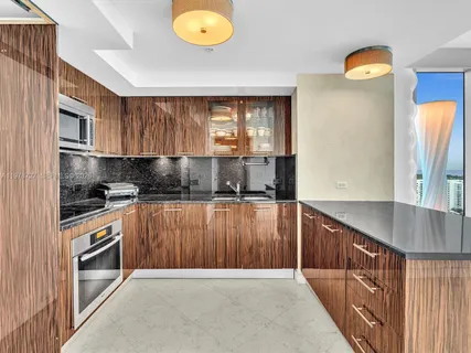 a kitchen with kitchen island granite countertop a sink window and refrigerator