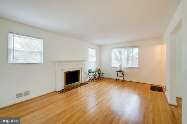 a view of empty room with wooden floor and fireplace