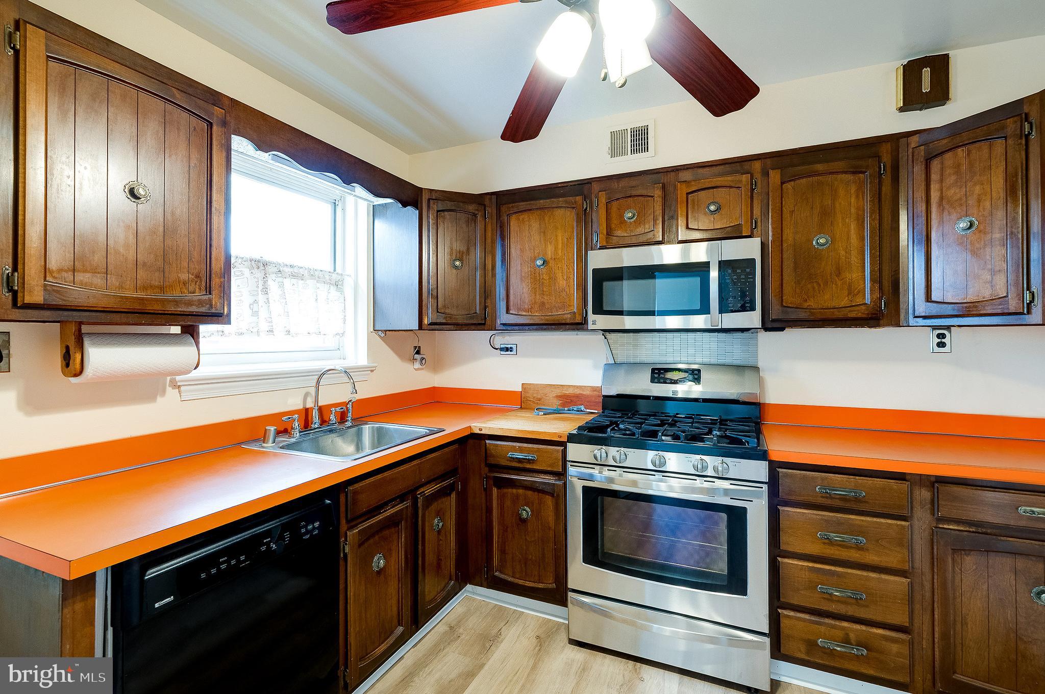 6159 1st Street Northeast Washington, DC 20011 - Photo 9 of 28 a kitchen with stainless steel appliances a stove sink microwave and cabinets