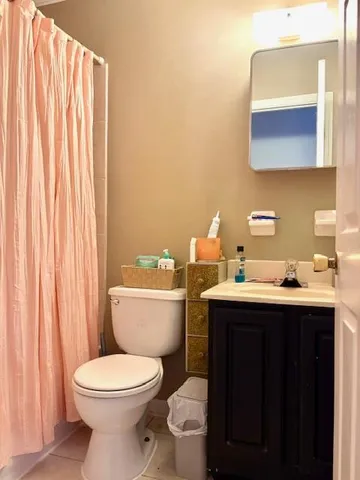 a bathroom with a toilet a sink and mirror