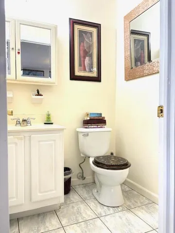 a bathroom with a toilet a sink and mirror