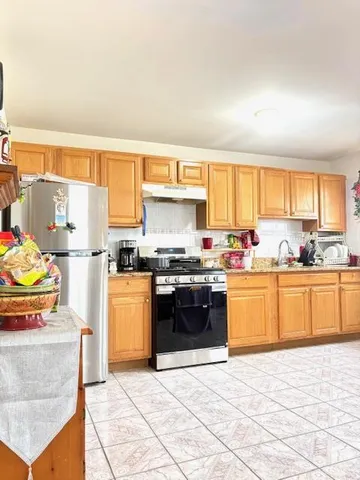 a kitchen with stainless steel appliances granite countertop a stove a sink and a refrigerator
