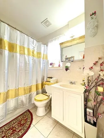 a view of a hallway with wooden floor and a bathroom