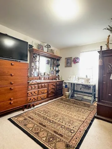 a large bed sitting in a bedroom next to a window with a flat screen tv
