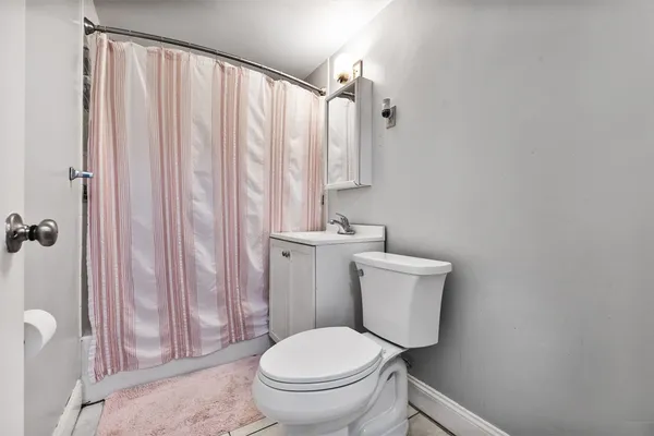 a white toilet sitting next to a shower curtain