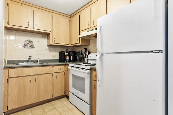 a kitchen with appliances a sink and cabinets